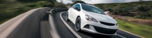 White car cornering in mountain road with speed blur